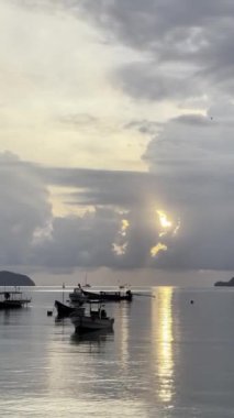 Arka planda okyanusta tekneler. Batan güneş. Resimli bir manzara. HDR kalitesinde dikey 4k video