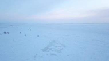 Manzara, arka planda birçok ağaç bulunan kalın bir kar tabakasıyla kaplıdır. Dondurucu soğuklar açık gökyüzüne karşı güzel bir kış manzarası yarattı.