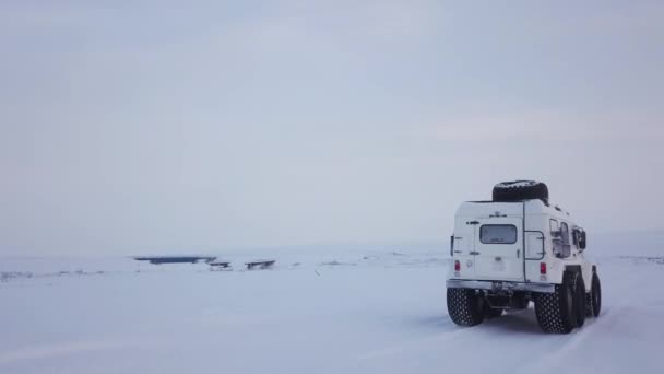Vit Suv Med Bildäck Navigerar Genom Ett Snöfält Hjulen Lämnar — Stockvideo