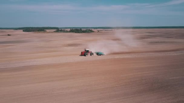 在清澈的天空和蓬松的云彩下 鸟瞰着拖拉机在沙漠中翻土的景象 — 图库视频影像