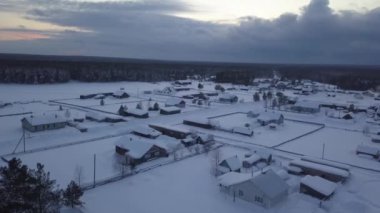 Beyaz karla kaplı küçük bir köyün güzel bir hava manzarası. Kamera, karla kaplanmış büyüleyici evleri ve ağaçları yakalıyor ve güzel bir kış manzarası yaratıyor.