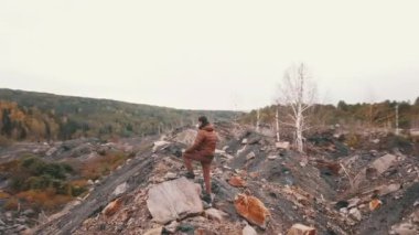 Engebeli sonbahar ormanlarında kayalara tırmanan bir insan, ağaçlarla çevrili cesur ve maceraperest bir ruha sahiptir.