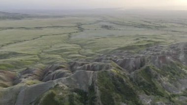 Canlı, yemyeşil manzaraları ve çarpıcı yuvarlanan tepeleri gösteren nefes kesici bir hava görüntüsü.