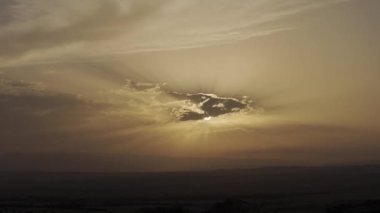 Nefes kesici bir günbatımı dramatik bulutlar ve yumuşak, altın renkler sergiliyor, doğal temalı görüntüler için mükemmel.