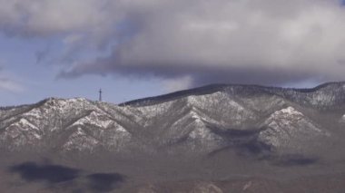 Nefes kesici bir manzara karla kaplı dağları çarpıcı bir şekilde benzersiz bulut oluşumlarıyla çevreler.