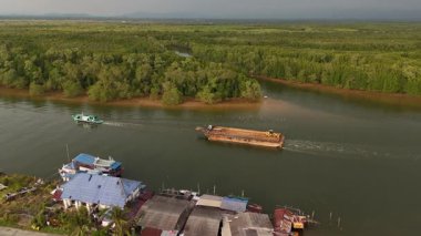 Çarpıcı bir insansız hava aracı Tayland 'da bir nehir yakalıyor, tekneleri ve canlı yeşil manzarası var.