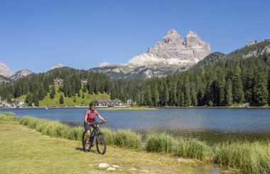 İtalya 'nın güney Tirol kentindeki Dolomite dağlarında Lavaredo' nun ünlü tepelerinin altında Misurina Gölü kıyısında elektrikli dağ bisikletini sürmüş.