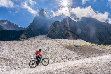 Innichen, Tre cime Ulusal Parkı, Güney Tirol, İtalya yakınlarındaki Sexten Dolomites kasabasında elektrikli dağ bisikletine binen son sınıf güzel bir kadın. 