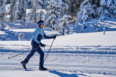 Avusturya 'nın Vorarlberg kentindeki Bregenz Ormanı' nın Hochhaedrich bölgesinde kayak yapan hoş ve aktif yaşlı bir kadın.