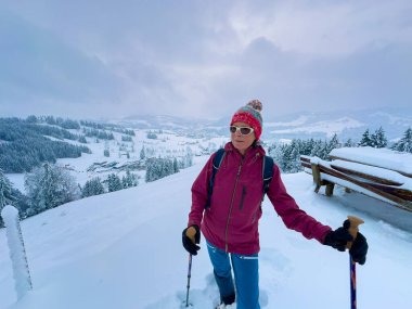 Allgau Alpleri, Bavyera, Almanya 'da kar altında kar ayakkabılarıyla yürüyüş yapan hoş ve aktif bir son sınıf öğrencisi.