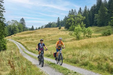 Avusturya, Vorarlberg, Sibratsgfll yakınlarındaki Bregenz Ormanı 'nda bisiklet turunda eğlenen iki son sınıf öğrencisi kız arkadaş.