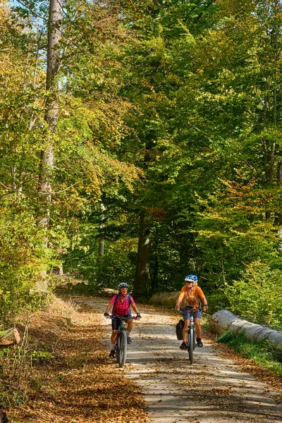 素敵なシニアガールフレンドは ドイツのバーデン ウォルテンベルクのシュヴァーヴェヴィッチアルバの秋の森で自転車で自転車をサイクリング — ストック写真
