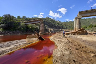 Bisikletli hoş bir kadın Rio Tinto nehri boyunca doğal kırmızı suyuyla Endülüs, İspanya 'da bisiklet turunda.