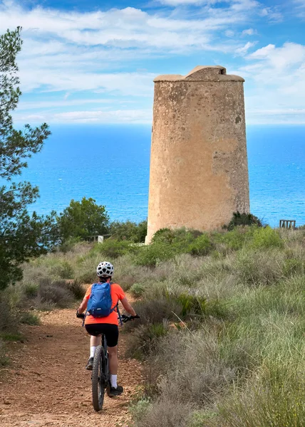İspanya, Endülüs, Nerja yakınlarındaki Costa Blanca sahil şeridinde son sınıf öğrencisi güzel bir bayan elektrikli dağ bisikletiyle bisiklet sürüyor.