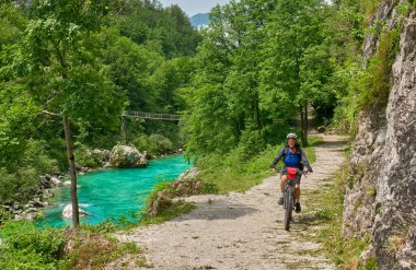 Slovenya 'daki Triglav Ulusal Parkı' nda elektrikli dağ bisikletiyle Soca Nehri boyunca bisiklet turuna çıkan hoş bir son sınıf öğrencisi. 