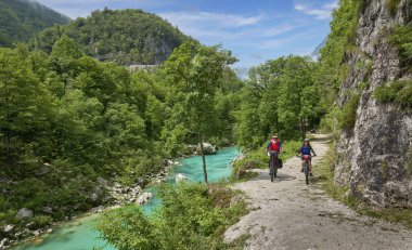 Slovenya 'nın Kobarid kenti yakınlarındaki Triglav Ulusal Parkı' ndaki River Soca Vadisi 'nde bisiklet turunda aktif kıdemli bir çift.