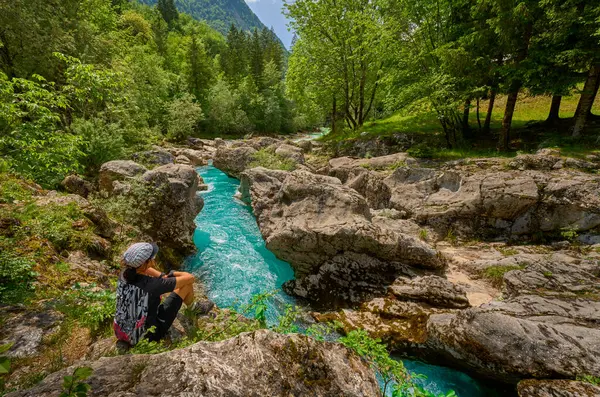 Slovenya 'daki Julian Alpleri' nin Triglav Ulusal Parkı 'ndaki Soca Nehri boyunca bir yürüyüş turunda dinlenen kadın.