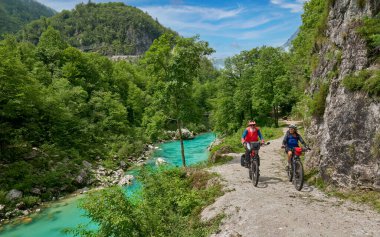 Slovenya 'nın Kobarid kenti yakınlarındaki Triglav Ulusal Parkı' ndaki River Soca Vadisi 'nde bisiklet turunda aktif kıdemli bir çift.