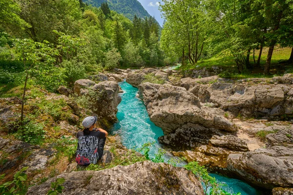 Slovenya 'daki Julian Alpleri' nin Triglav Ulusal Parkı 'ndaki Soca Nehri boyunca bir yürüyüş turunda dinlenen kadın.