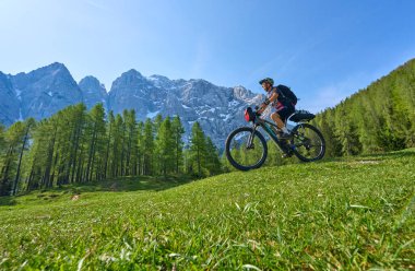 Slovenya 'daki Kranska Gora' nın yukarısındaki Triglav Ulusal Parkı 'ndaki Vri Geçidi' nde E dağ bisikleti turundaki neşeli, aktif son sınıf öğrencisi kadın.