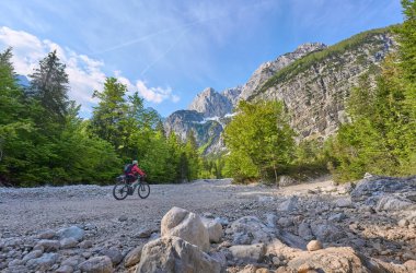 Slovenya 'daki Triglav Ulusal Parkı' nda elektrikli dağ bisikletiyle Soca Nehri boyunca bisiklet turunda olan hoş bir kadın. 