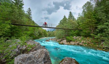 Slovenya 'daki Triglav Ulusal Parkı' nda elektrikli dağ bisikletiyle Soca Nehri boyunca bisiklet turunda olan hoş bir kadın. 