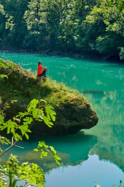 Slovenya 'daki Julian Alpleri' nin Triglav Ulusal Parkı 'ndaki Soca Nehri boyunca bir yürüyüş turunda dinlenen kadın.