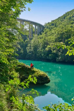 Slovenya 'daki Julian Alpleri' nin Triglav Ulusal Parkı 'ndaki Soca Nehri boyunca bir yürüyüş turunda dinlenen kadın.