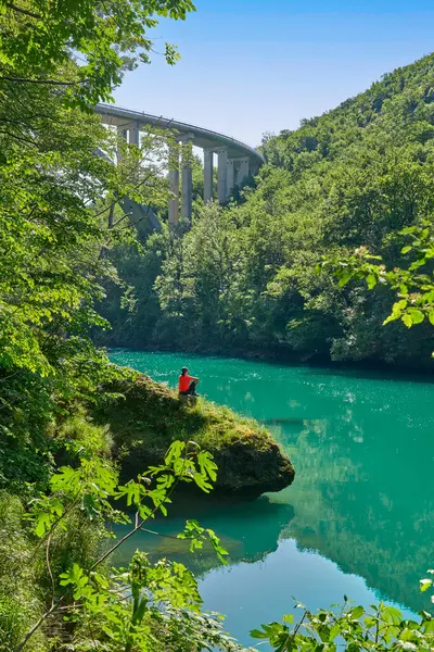 Slovenya 'daki Julian Alpleri' nin Triglav Ulusal Parkı 'ndaki Soca Nehri boyunca bir yürüyüş turunda dinlenen kadın.