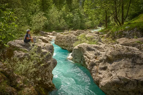 Slovenya 'daki Julian Alpleri' nin Triglav Ulusal Parkı 'ndaki Soca Nehri boyunca bir yürüyüş turunda dinlenen kadın.