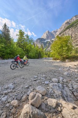 Slovenya 'nın Kobarid kenti yakınlarındaki Triglav Ulusal Parkı' ndaki River Soca Vadisi 'nde bisiklet turunda aktif kıdemli bir çift.