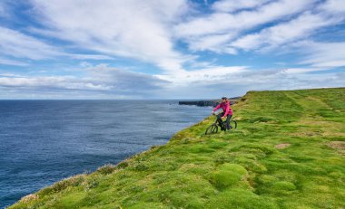 Dağ bisikletli hoş, yaşlı bir kadın. Dunmore Tepesi 'nin tepelerinde bisiklet sürüyor. Kilballyowen, County Limerick' in yakınında.