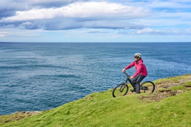 Dağ bisikletli hoş, yaşlı bir kadın. Dunmore Tepesi 'nin tepelerinde bisiklet sürüyor. Kilballyowen, County Limerick' in yakınında.