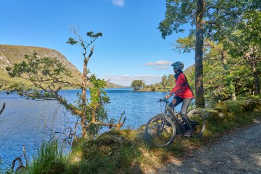 Dağ bisikletli hoş, yaşlı bir kadın Glenveagh Ulusal Parkı 'ndaki Lough Beagh' de bisiklet sürüyor. Churchill, Donegal, Kuzey İrlanda Cumhuriyeti yakınlarında.