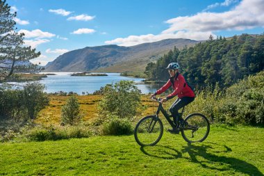 Dağ bisikletli hoş, yaşlı bir kadın Glenveagh Ulusal Parkı 'ndaki Lough Beagh' de bisiklet sürüyor. Churchill, Donegal, Kuzey İrlanda Cumhuriyeti yakınlarında.