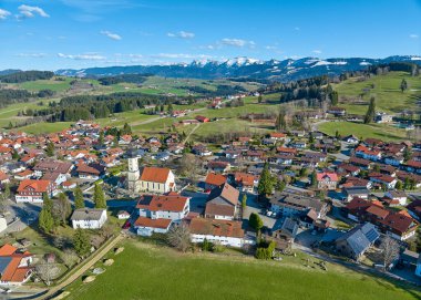 Allgaeu Alpleri, Bavyera, Almanya 'da kar kaplı Nagelfluh dağ zinciriyle Earla baharı Oberreute köyünün hava manzarası