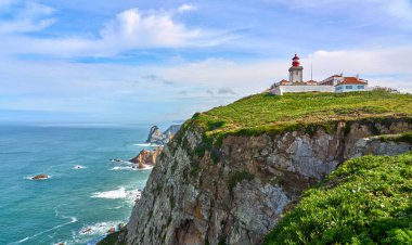 Cabo da Roca 'daki deniz feneri. Portekiz' in Atlantik Okyanusu kıyısındaki Cascais yakınlarında Avrupa 'nın en büyük tükürüğü.