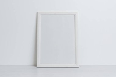 Duvara yaslanmış beyaz çerçeve modeli. Sanat sunumu için temiz, boş bir yüzey