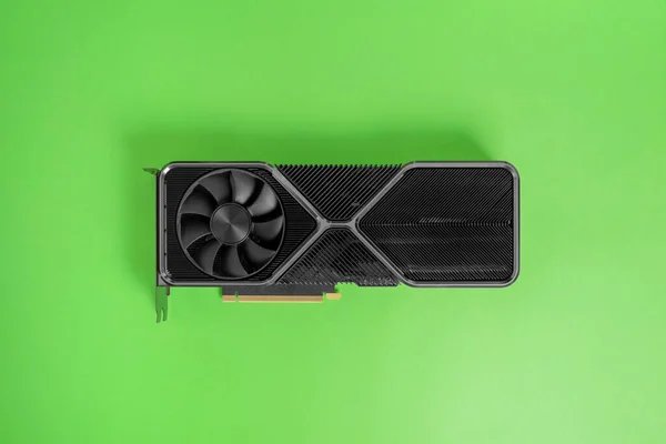 Modern graphic card on green surface. Massive radiator with two coolers. Modern gaming and rendering graphics card. Top view, flat lay
