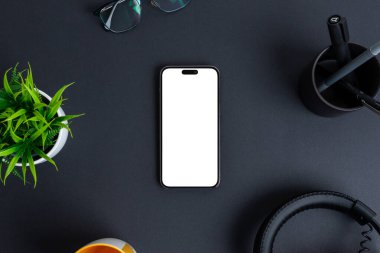 Telefon modeli siyah masanın üzerinde. Uygulama tasarımı promosyonu için beyazla izole edilmiş ekran. Üst görünüm, düz konum