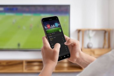 Adam TV 'de futbol maçı izliyor ve internetten bahis oynuyor.