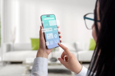 Kullanıcı arayüzü ve deneyimli konsept uygulaması akıllı telefonda kadınların elinde. Uçan uygulama modülleri ile temiz tasarım