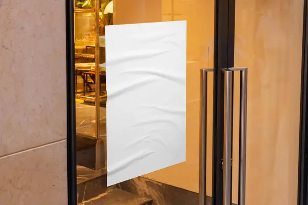 Wrinkled, blank A3 poster, adhered to a shop door\'s glass window. Clean surface for discount or sale promotion.
