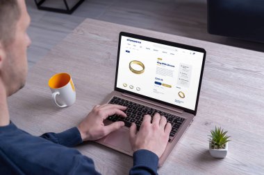 Adamın biri ecommerce sitesinden yüzük satın alıyor. Dijital platformlar vasıtasıyla mücevher satın alma kavramını resmetmek