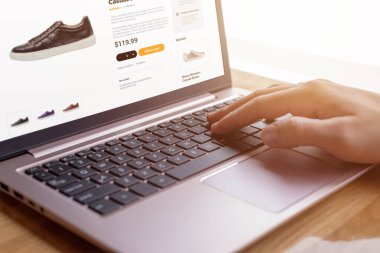 Eller klavyede modern ayakkabılar arıyor. E-ticaret arayüzü kavramı. Ayakkabı meraklıları için kusursuz dijital alışveriş deneyimi