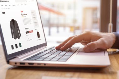 Bilgisayarda daktilo eden ellerin yakın çekimi, internetten erkek ceketi alışverişi. Moda tutkunları için modern dijital alışveriş deneyimi