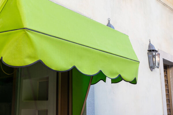 Green awning in front of a shop window. Blank space for printing logo or text. Perfect for storefront advertising and branding opportunities