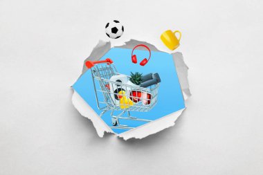 Ürünlerle dolu bir alışveriş arabasıyla kağıtta yırtık pırtık bir delik. Yaratıcı bir bakış açısıyla alışveriş ve çeşitli ürünler satın alma kavramı