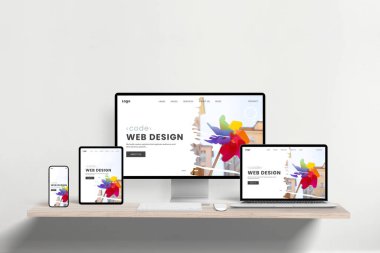 Tepkili web tasarım stüdyo sayfası ofis masasında dizüstü bilgisayar, telefon, tablet ve tablet arasında gösteriliyor. Profesyonel ağ geliştirme için çapraz aygıt işlevselliği ve modern sunum gösteriliyor