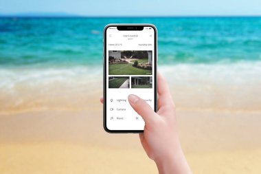 Sahildeki güvenlik kameralarını akıllı telefon uygulaması kullanarak izlemek deniz kenarında tatilin tadını çıkarırken iç huzuru sağlamak ve arka bahçeye göz kulak olmak.